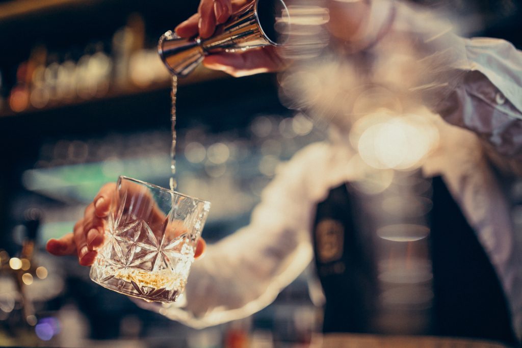 Handsome bartender making alcohol free drinking and cocktails at a counter