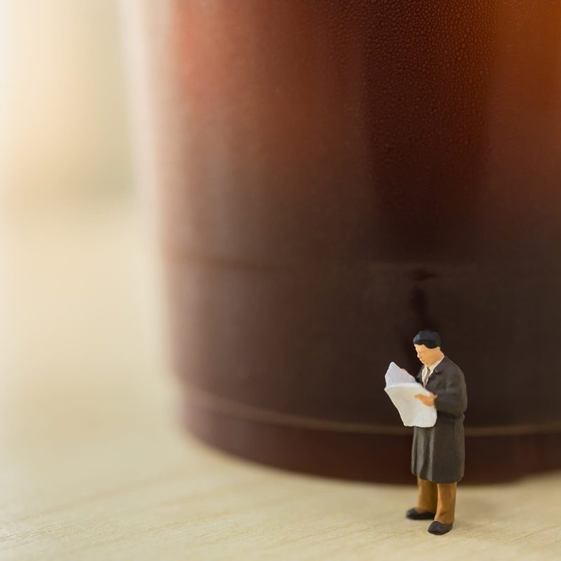 Una figurita de un hombre leyendo el periódico