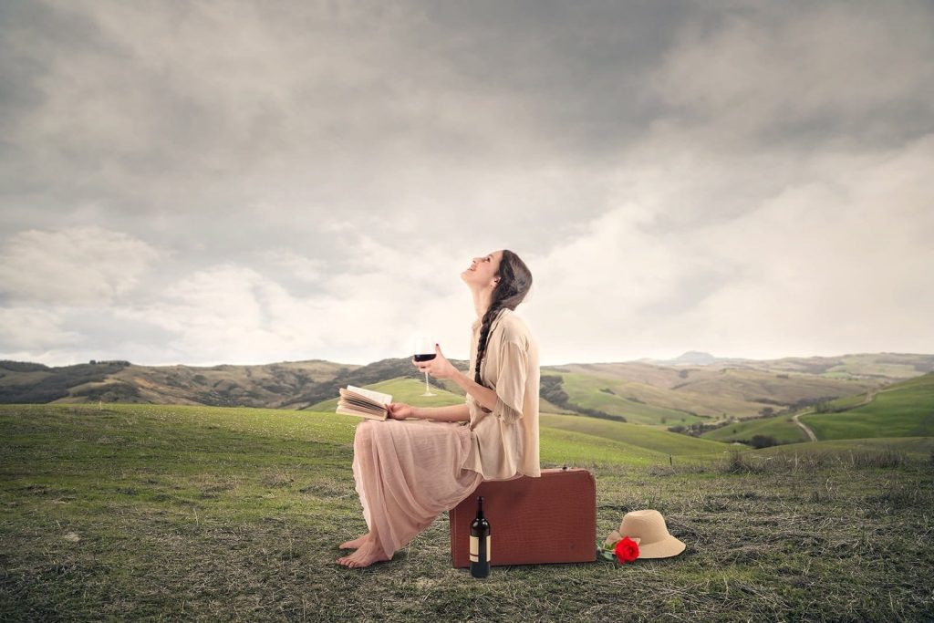 A girl holding a glass of wine and a book. Sant Jordi 2020 The Blue Dolphin Store